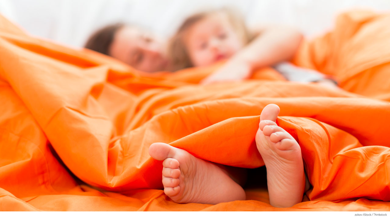 Mother and daughter under covers