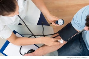 female nurse checking man's blood pressure