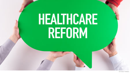Four pairs of hands holding green quote sign labeled “Healthcare Reform”