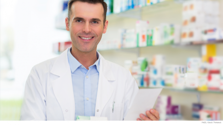 Pharmacist holding a list of prescription drug plan tier pricing