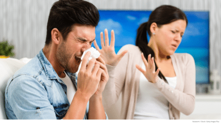 Man sneezing at home