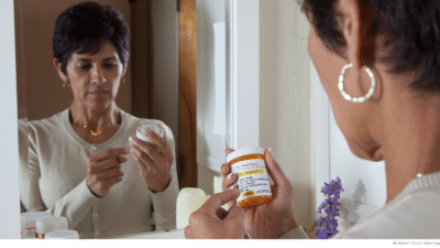Mature woman looking at prescription bottle