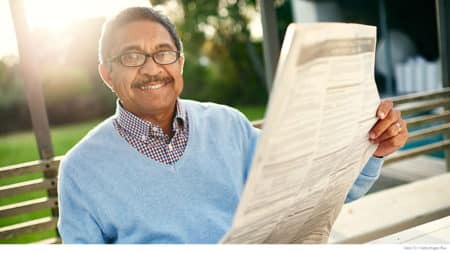 Mature man wearing glasses to read the paper